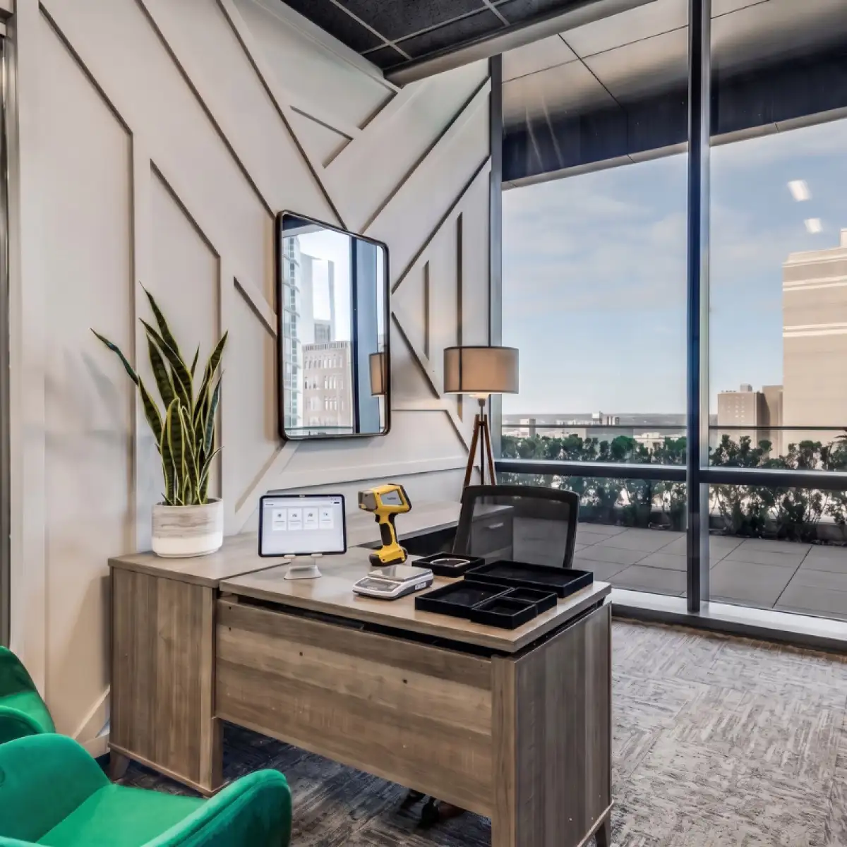 A private American Gold Tour evaluation office: desk with a metal analyzer, precision scale and jewelry trays, floor-to-ceiling windows behind it
